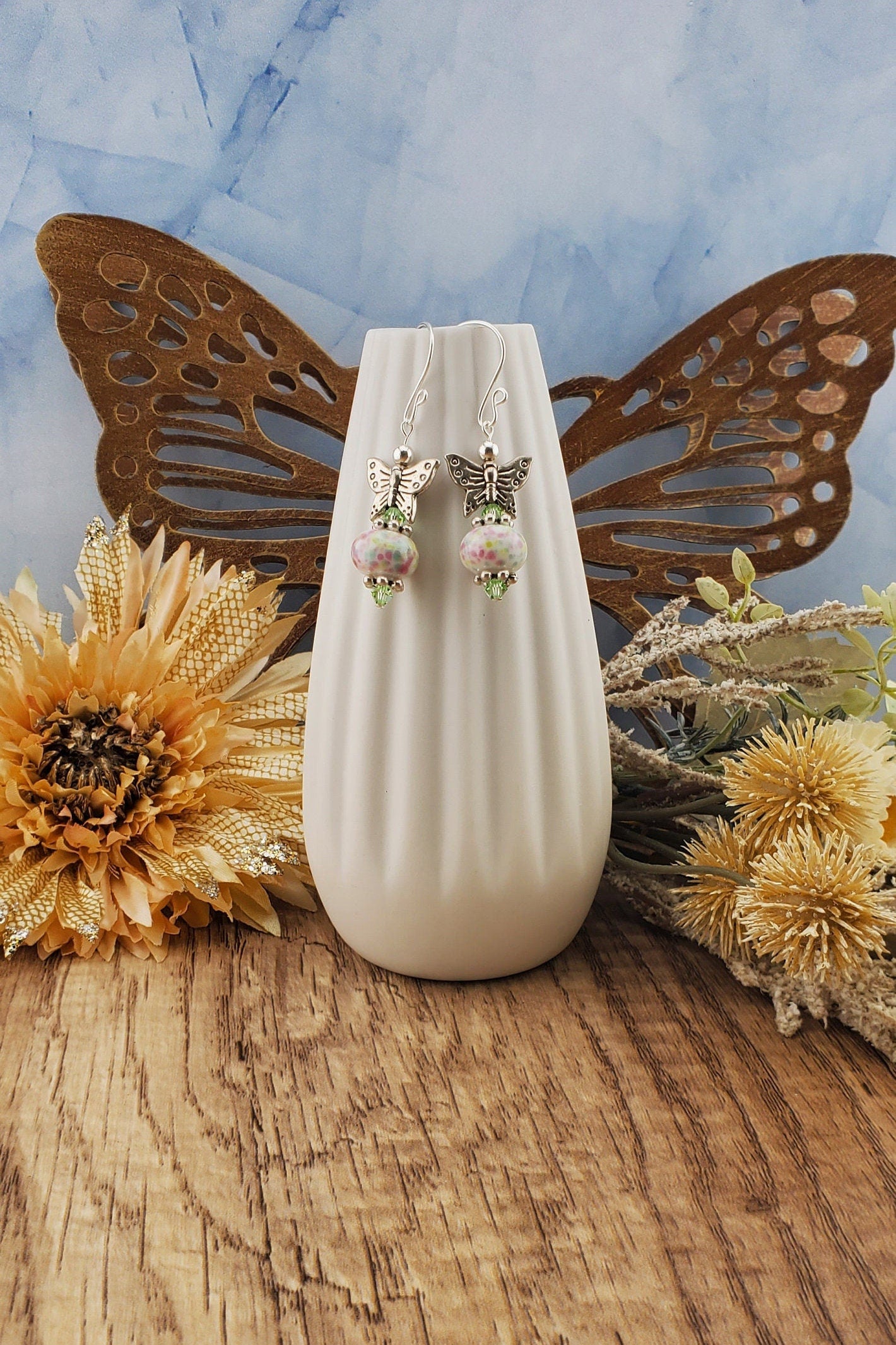 SF Fluttering Spring Confetti Artisan Glass Earrings, Lampwork Glass Bead handcrafted by a talented artisan, Silver Filled Earring Wire. Pink, Green and Blue speckled lampwork bead with green crystal accents and a pewter butterfly.