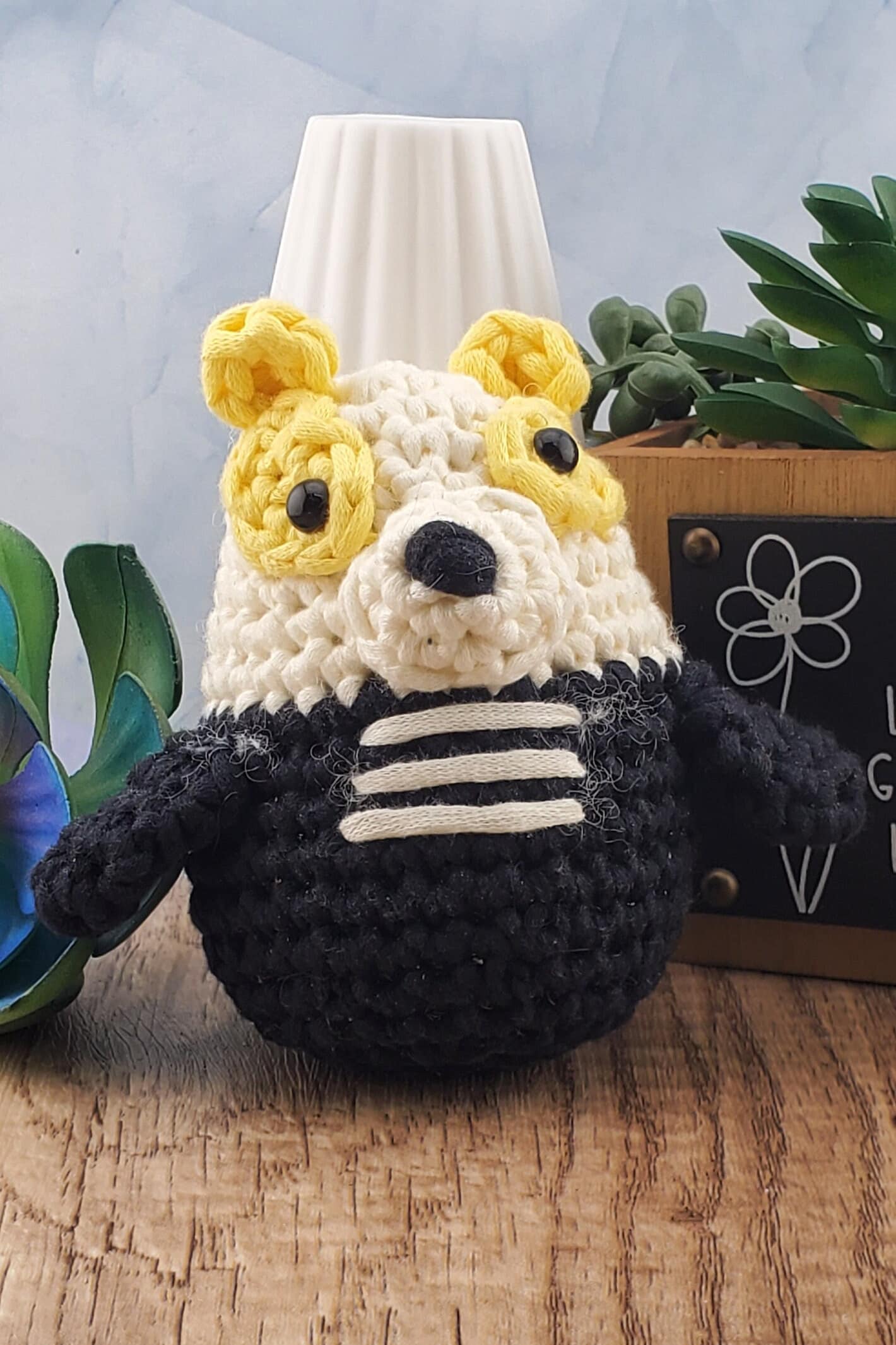 Handcrafted crocheted badger buddy named Hudson. White and black with yellow ears.