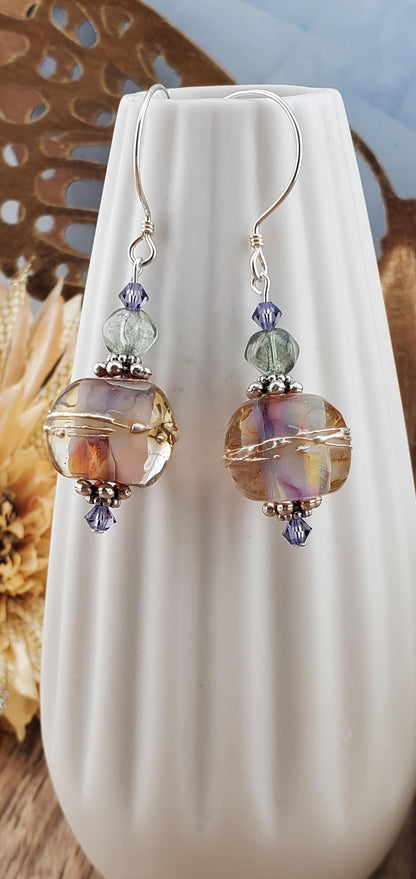 Mystical Wonders Artisan Glass Earrings, Lampwork Glass Bead handcrafted by a talented artisan, Sterling Silver Earring Wire. Shimmery purple and falls colors accented with green and purple crystal beads.