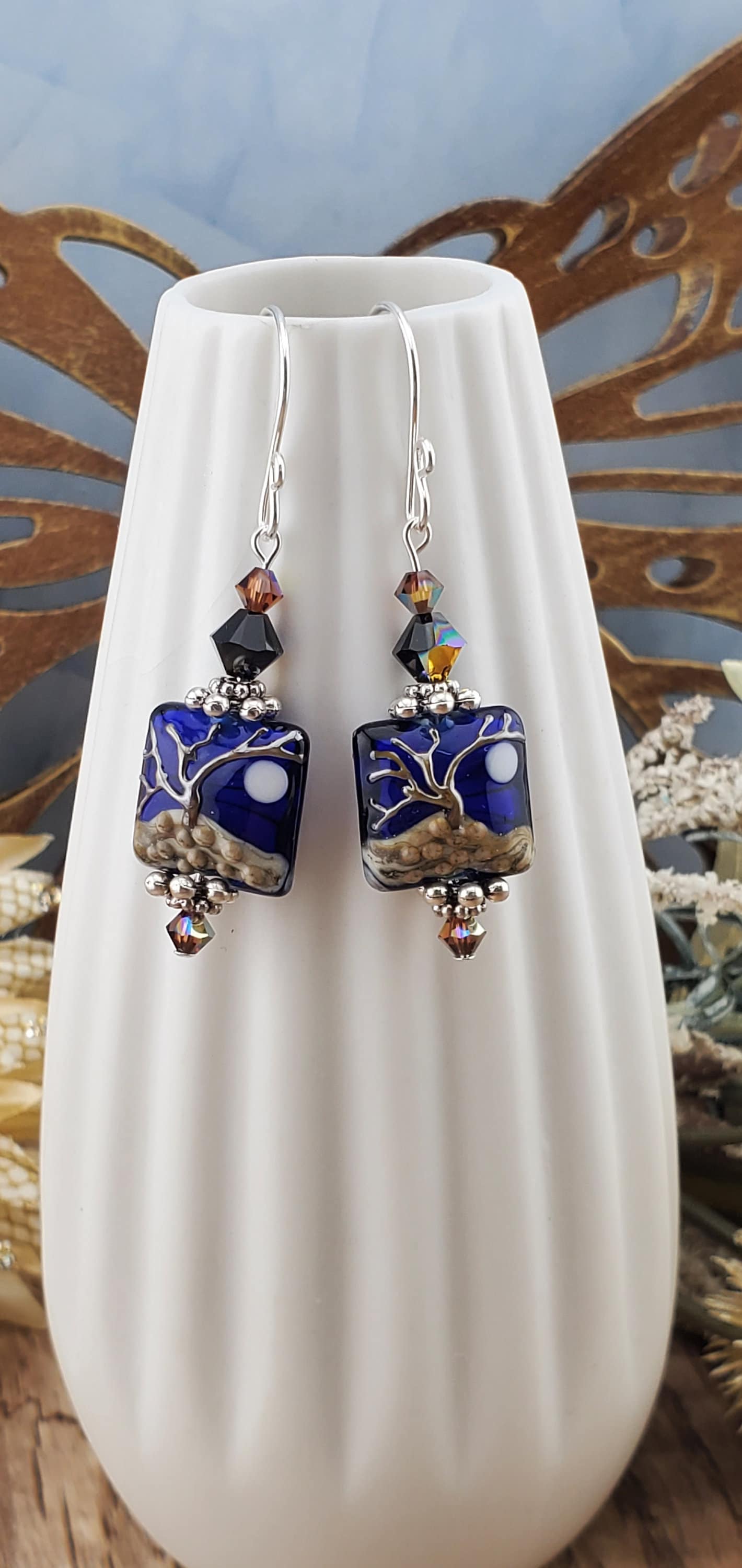 Cobalt Sky Earrings, Lamp work Glass Bead handcrafted by a talented artisan, Sterling Silver Earring Wire. Cobalt blue bead with copper tree in the foreground and a full moon.