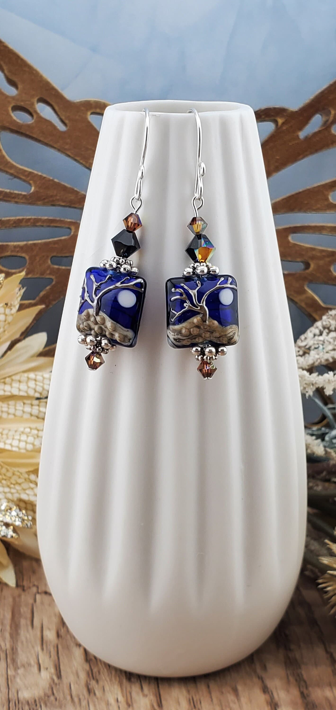 Cobalt Sky Earrings, Lamp work Glass Bead handcrafted by a talented artisan, Sterling Silver Earring Wire. Cobalt blue bead with copper tree in the foreground and a full moon.