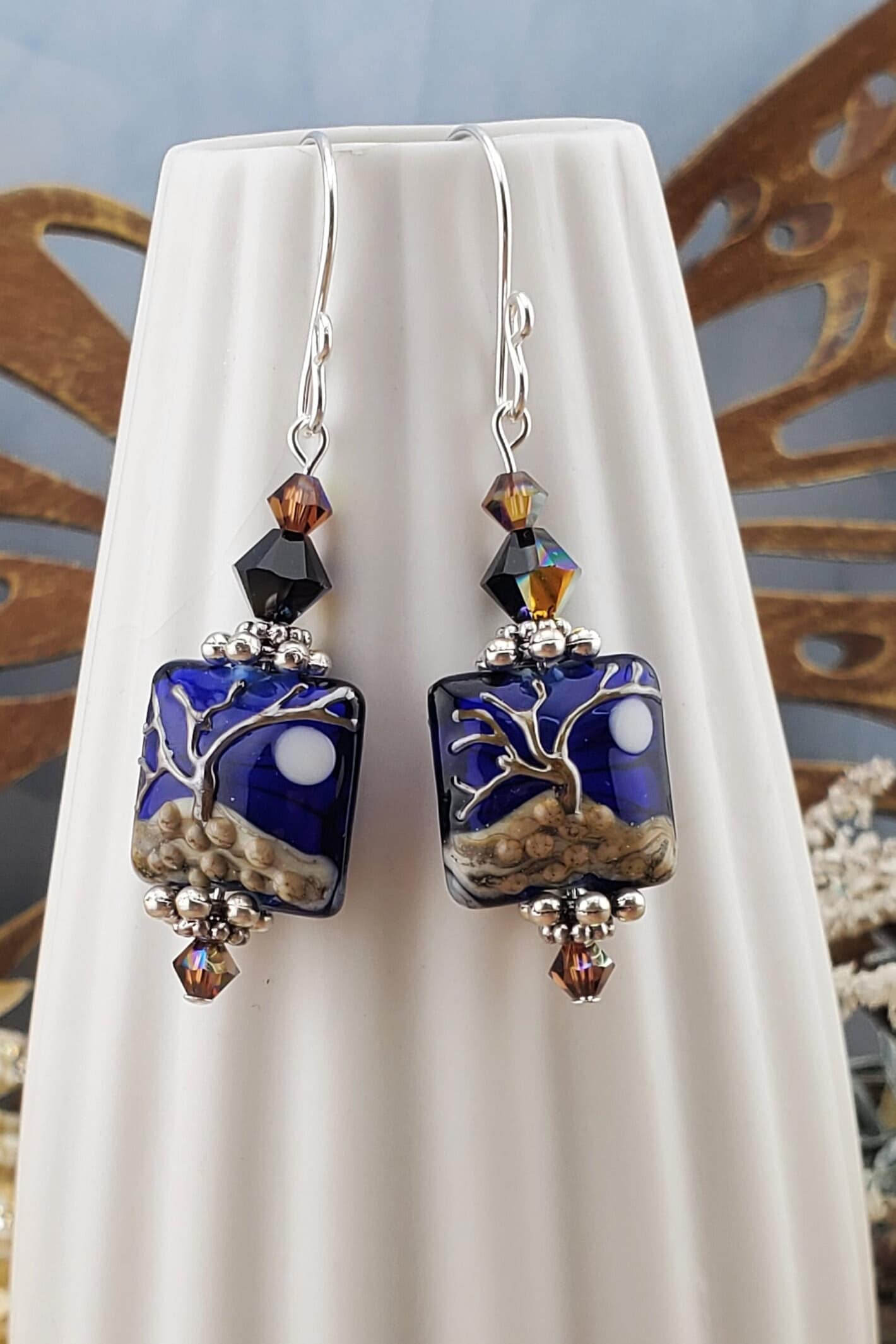 Cobalt Sky Earrings, Lamp work Glass Bead handcrafted by a talented artisan, Sterling Silver Earring Wire. Cobalt blue bead with copper tree in the foreground and a full moon.