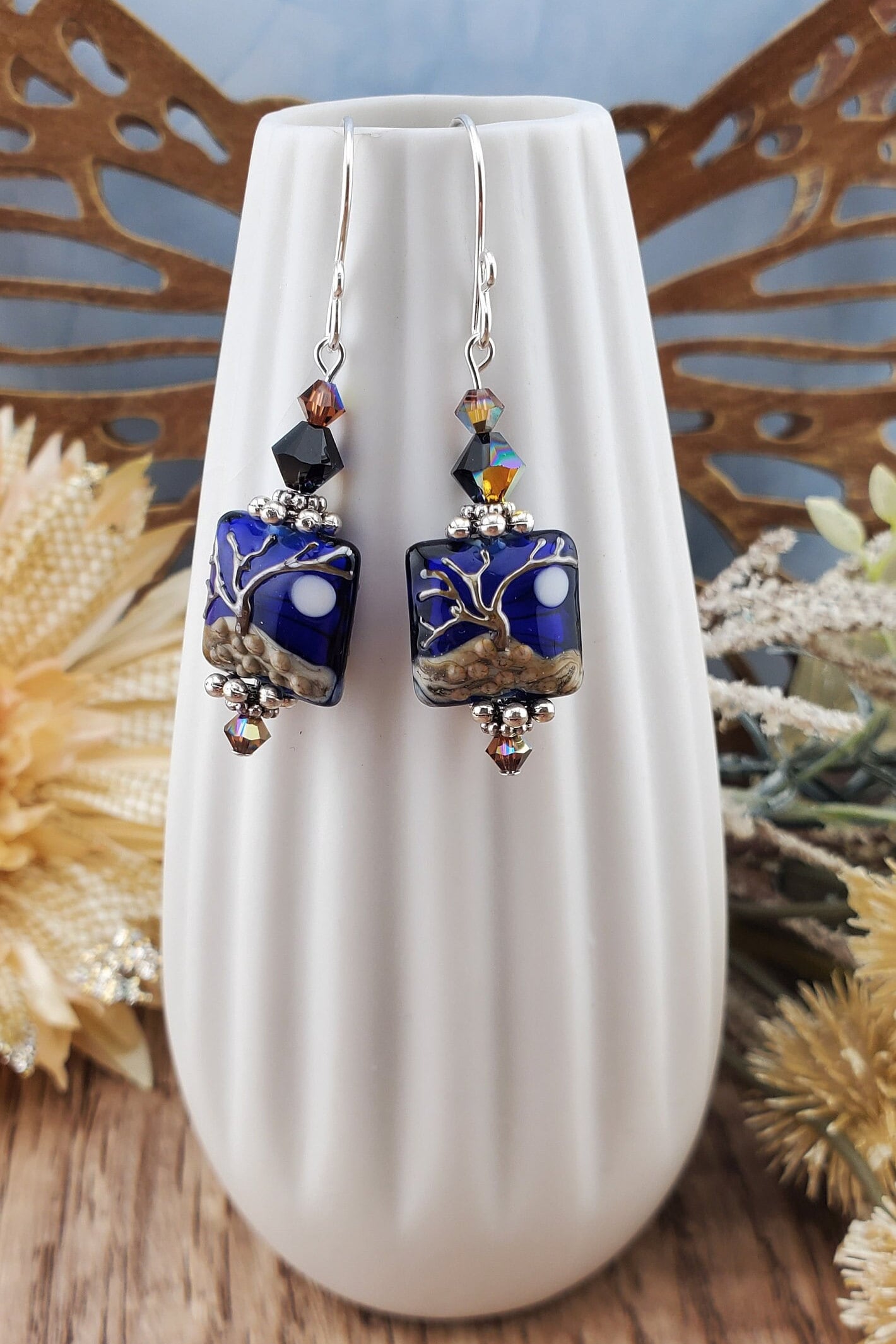 Cobalt Sky Earrings, Lamp work Glass Bead handcrafted by a talented artisan, Sterling Silver Earring Wire. Cobalt blue bead with copper tree in the foreground and a full moon.