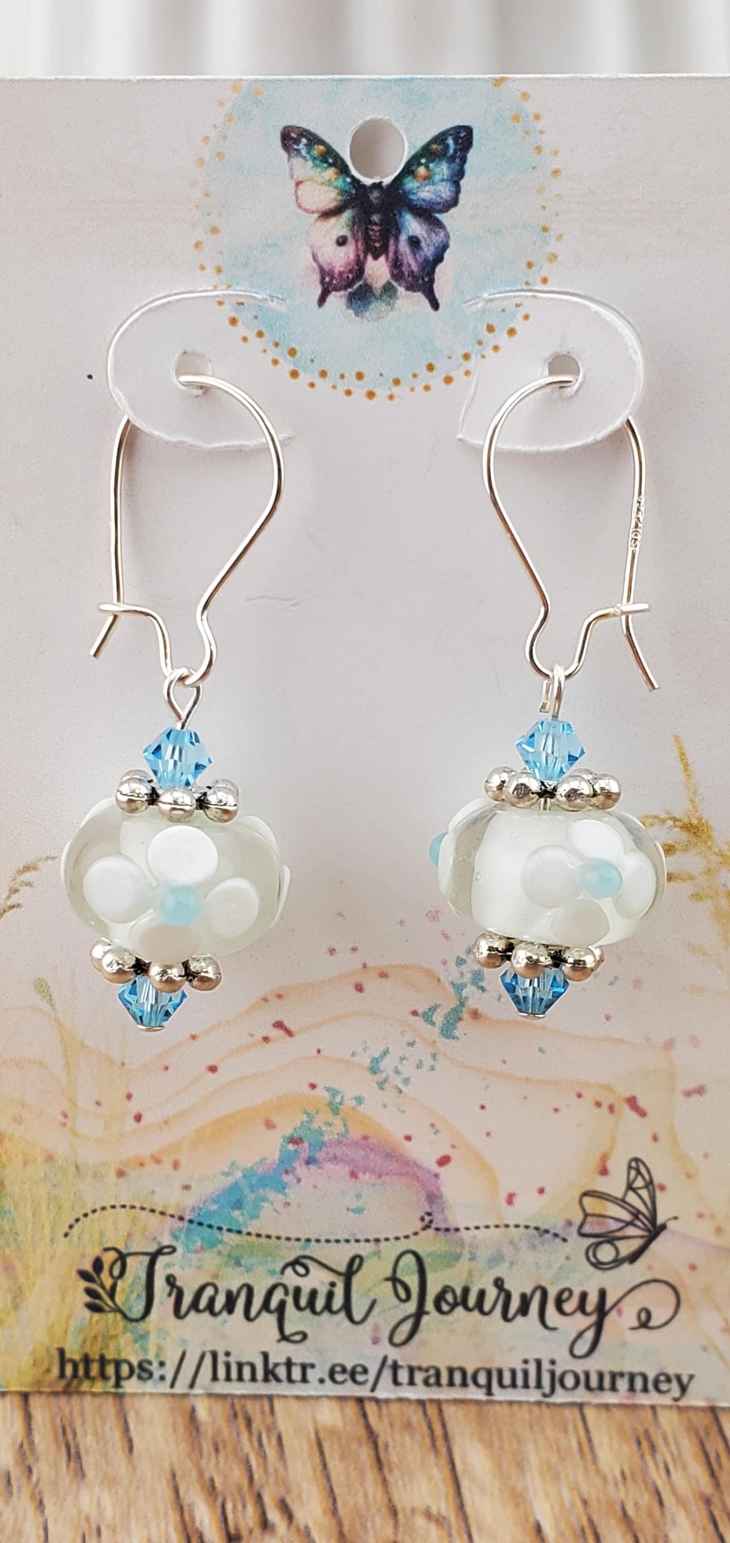 SF Baby Blue Blossoms. Artisan Glass Earrings, Lampwork Glass Bead handcrafted by a talented artisan, Silver Filled Earring Wire. White floral lampwork glass bead with baby blue accents.