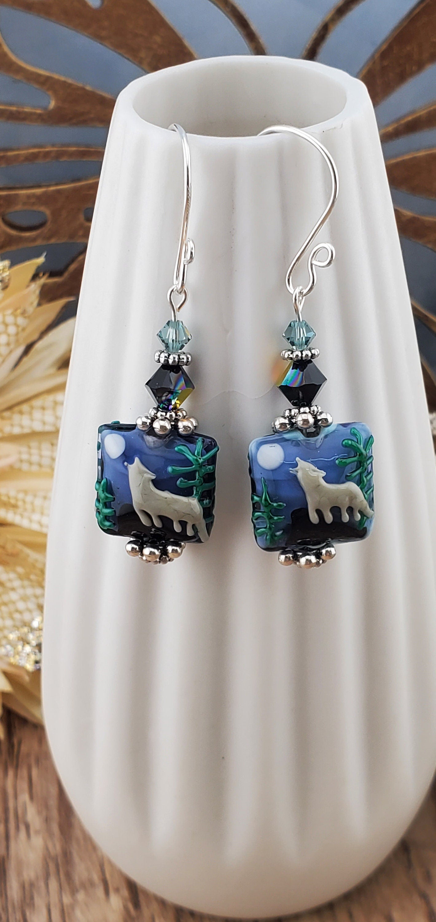 SF Twilight Serenade Artisan Glass Earrings, Lampwork Glass Bead handcrafted by a talented artisan, Silver Filled Earring Wire. Howling wolf under a full moon in the forest lampwork bead. Accented with blue crystals.