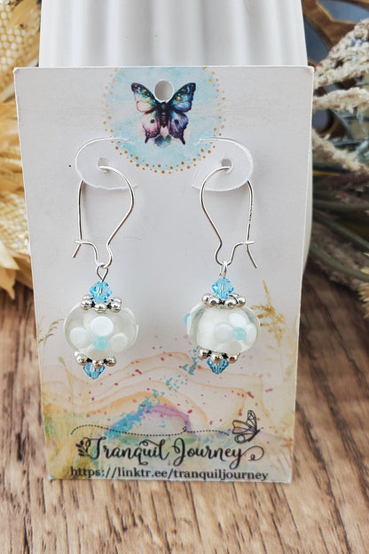 SF Baby Blue Blossoms. Artisan Glass Earrings, Lampwork Glass Bead handcrafted by a talented artisan, Silver Filled Earring Wire. White floral lampwork glass bead with baby blue accents.