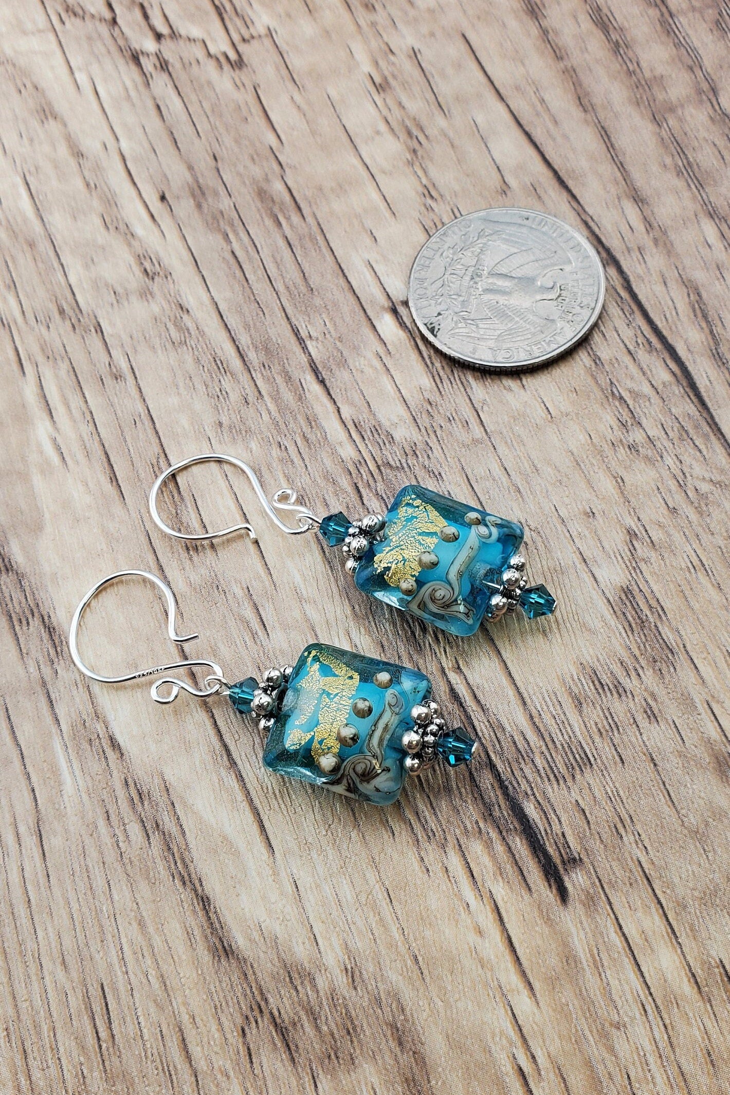 SF Golden Horizon Blues Artisan Glass Earrings, Lampwork Glass Bead handcrafted by a talented artisan, Silver Filled Earring Wire. Teal and golden colors fill this lampwork bead and it is accented with teal crystals.