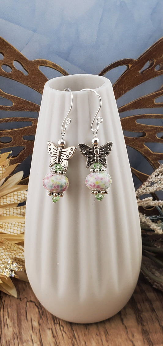 SF Fluttering Spring Confetti Artisan Glass Earrings, Lampwork Glass Bead handcrafted by a talented artisan, Silver Filled Earring Wire. Pink, Green and Blue speckled lampwork bead with green crystal accents and a pewter butterfly.