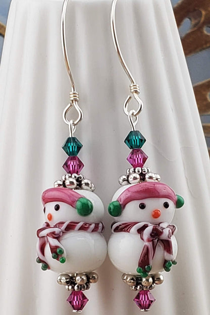 SS Blushing Snow Buddy Artisan Glass Earrings, Sterling Silver Earring Wire. Snowman with a pink scarf and green and pink crystal beads accenting the lampwork bead.