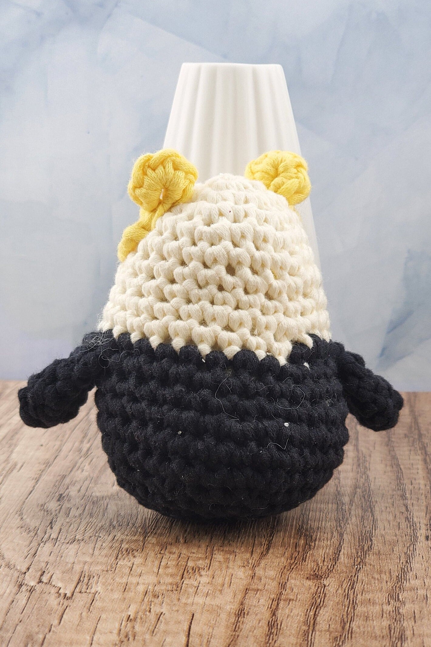 Handcrafted crocheted badger buddy named Hudson. White and black with yellow ears.