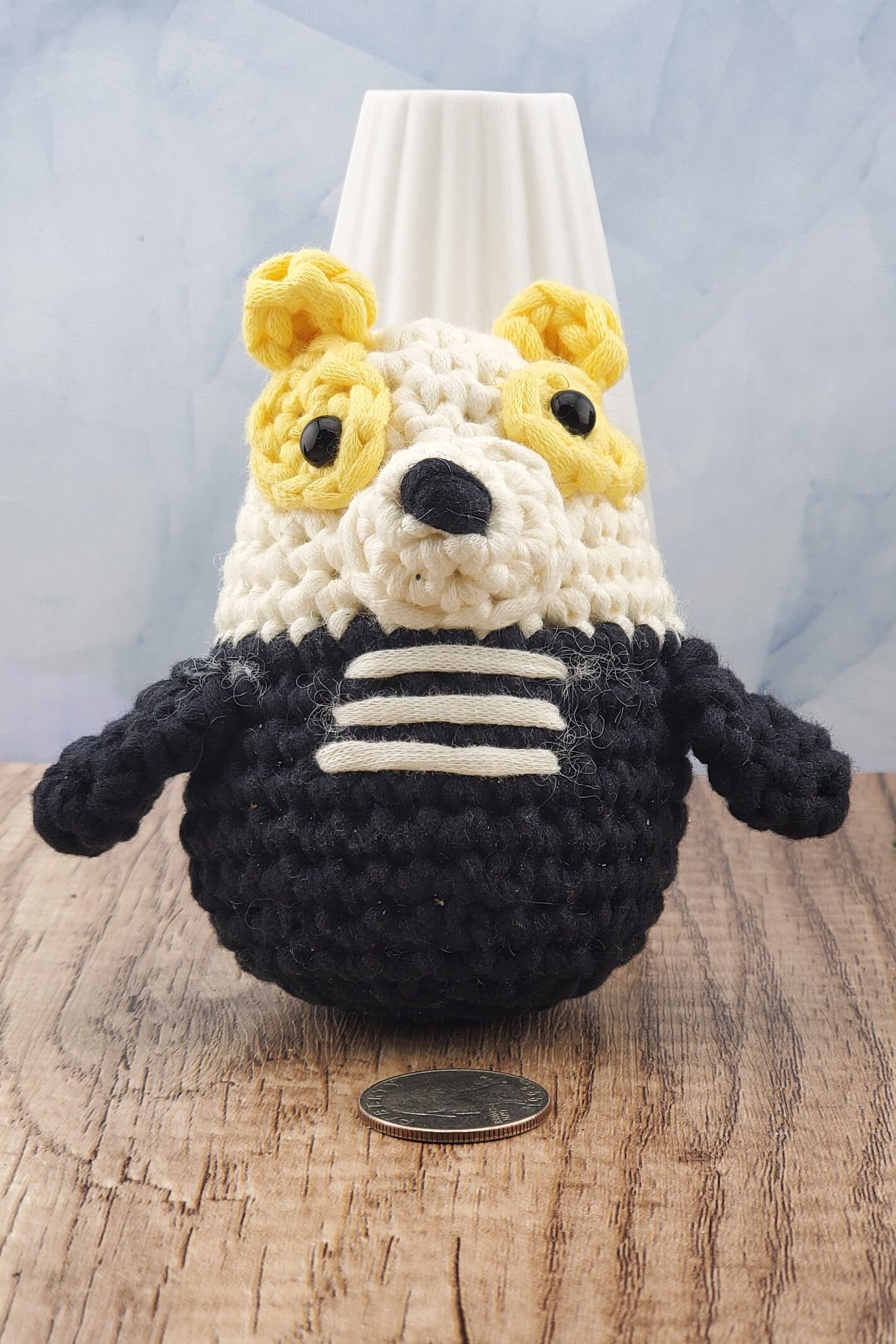 Handcrafted crocheted badger buddy named Hudson. White and black with yellow ears.