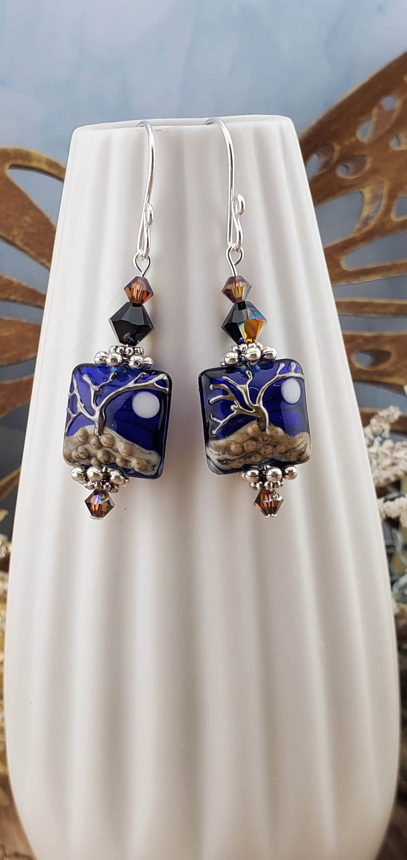 Cobalt Sky Earrings, Lamp work Glass Bead handcrafted by a talented artisan, Sterling Silver Earring Wire. Cobalt blue bead with copper tree in the foreground and a full moon.