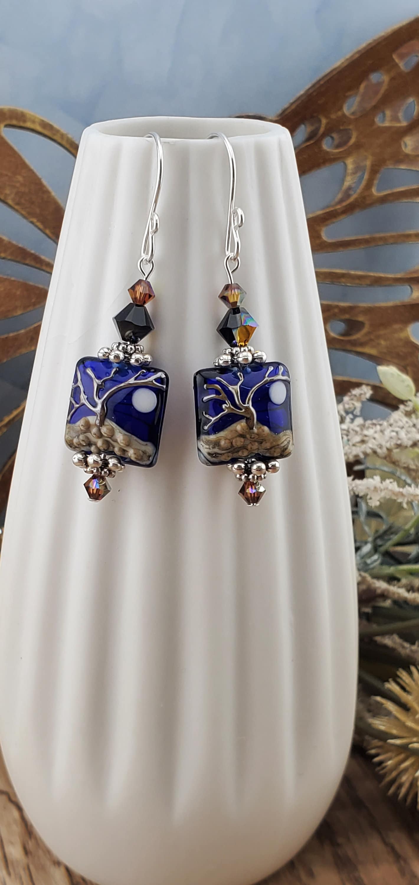 Cobalt Sky Earrings, Lamp work Glass Bead handcrafted by a talented artisan, Sterling Silver Earring Wire. Cobalt blue bead with copper tree in the foreground and a full moon.