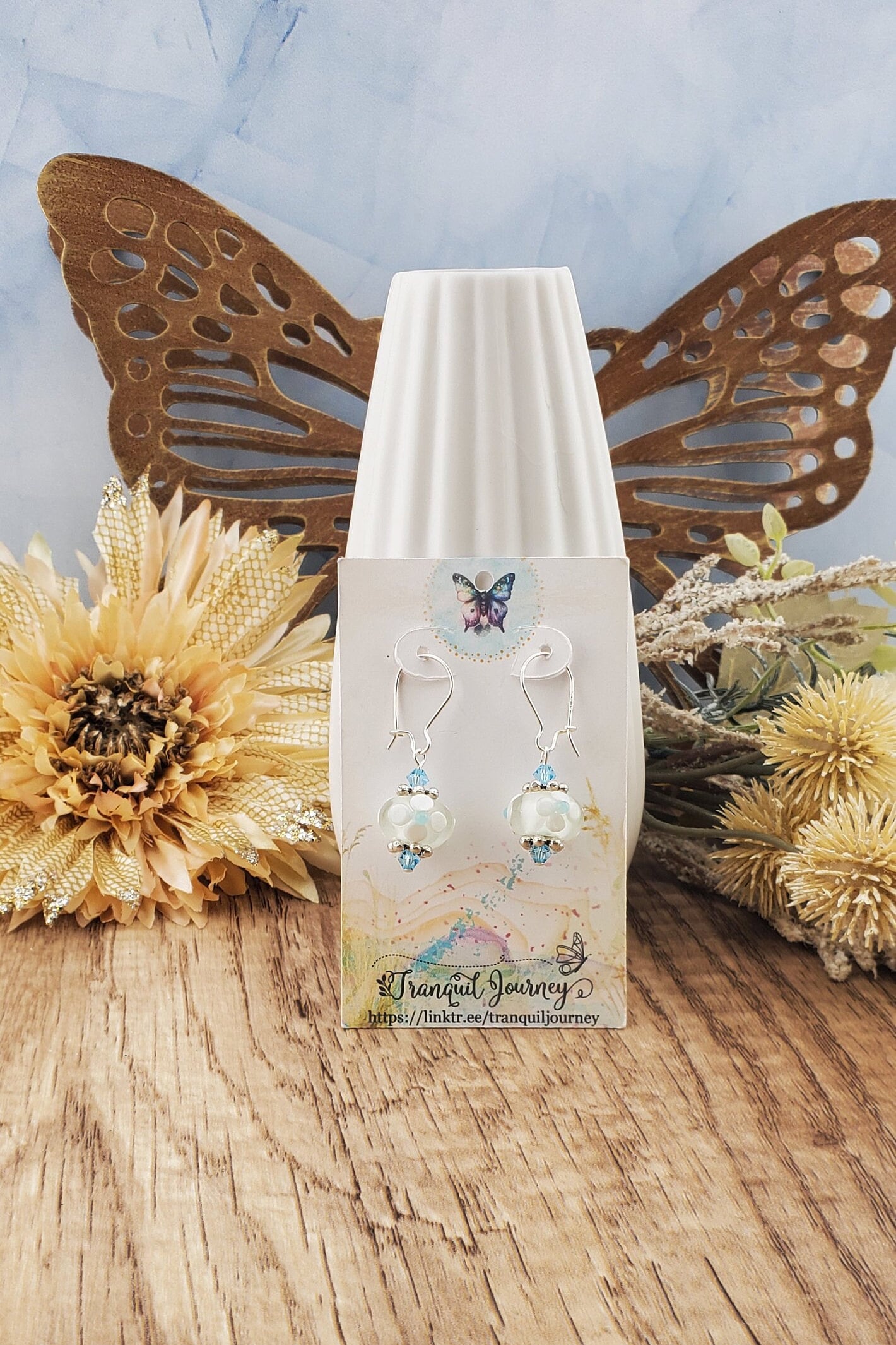 SF Baby Blue Blossoms. Artisan Glass Earrings, Lampwork Glass Bead handcrafted by a talented artisan, Silver Filled Earring Wire. White floral lampwork glass bead with baby blue accents.