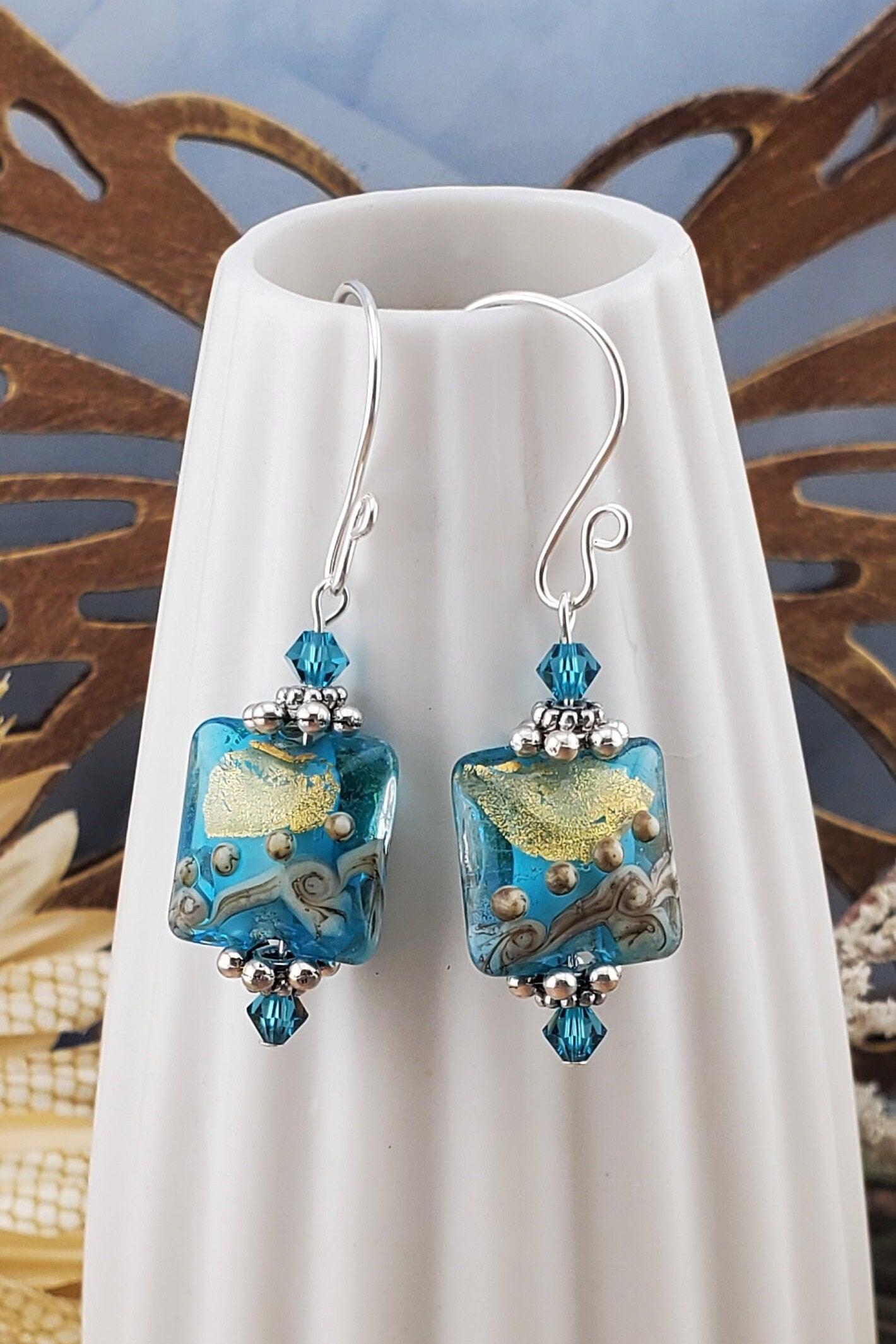 SF Golden Horizon Blues Artisan Glass Earrings, Lampwork Glass Bead handcrafted by a talented artisan, Silver Filled Earring Wire. Teal and golden colors fill this lampwork bead and it is accented with teal crystals.