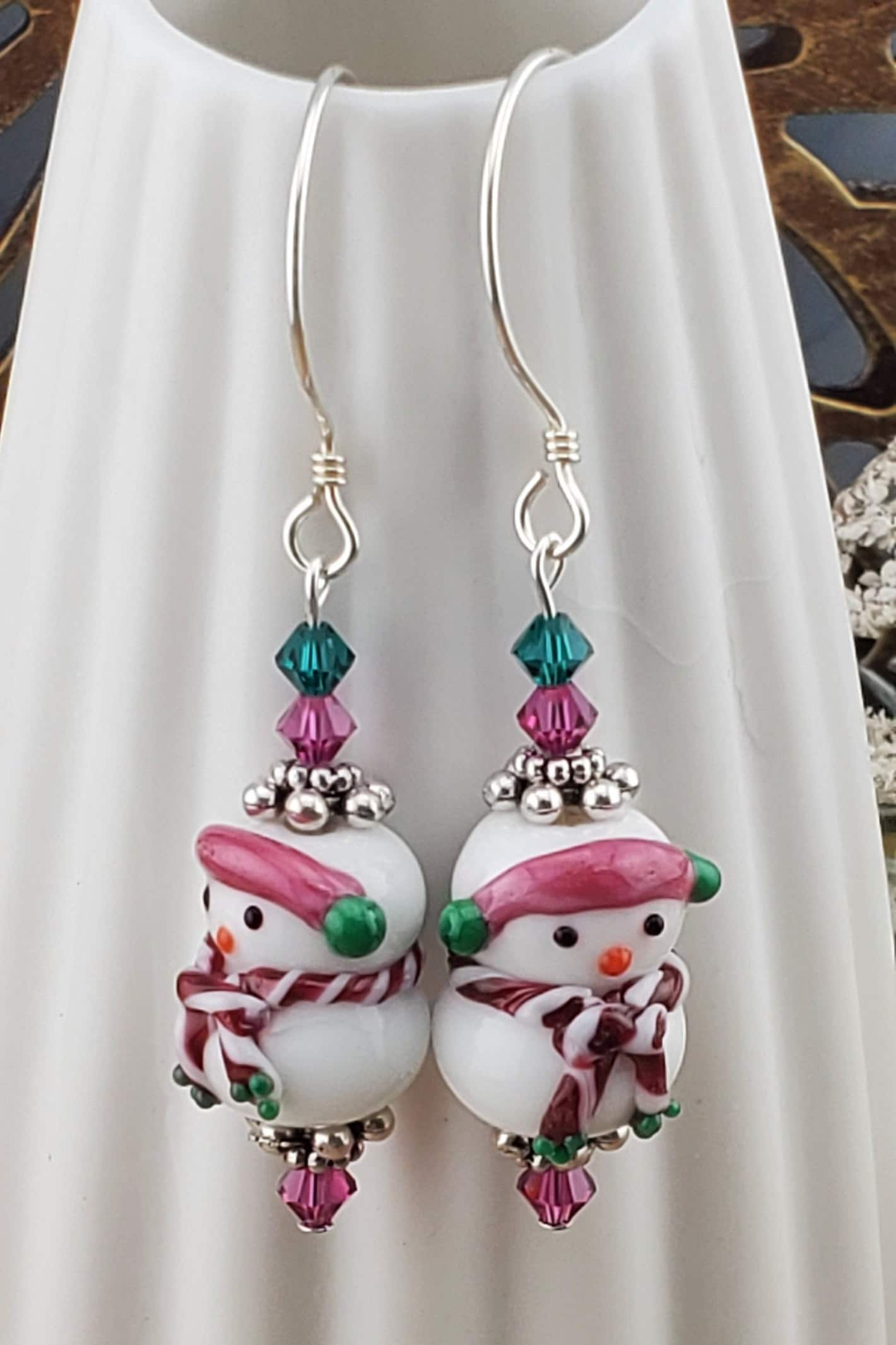 SS Blushing Snow Buddy Artisan Glass Earrings, Sterling Silver Earring Wire. Snowman with a pink scarf and green and pink crystal beads accenting the lampwork bead.