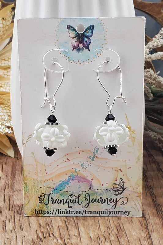 SF Snow Petal Sparkle Artisan Glass Earrings, Lampwork Glass Bead handcrafted by a talented artisan, Silver Filled Earring Wire. White floral lampwork bead accented by black crystals.