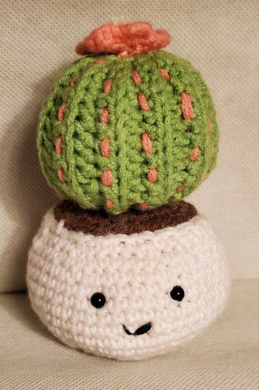 Handcrafted crochet cactus buddy named Sahara chilling in a brown pot, flaunting a sassy pink flower