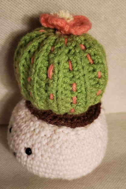 Handcrafted crochet cactus buddy named Sahara chilling in a brown pot, flaunting a sassy pink flower